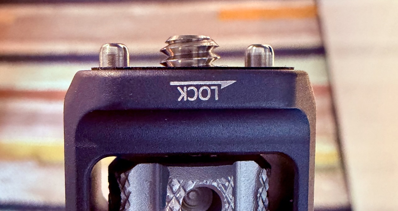 Close-up of a 1/4-inch camera screw flanked by two anti-twist locating pins