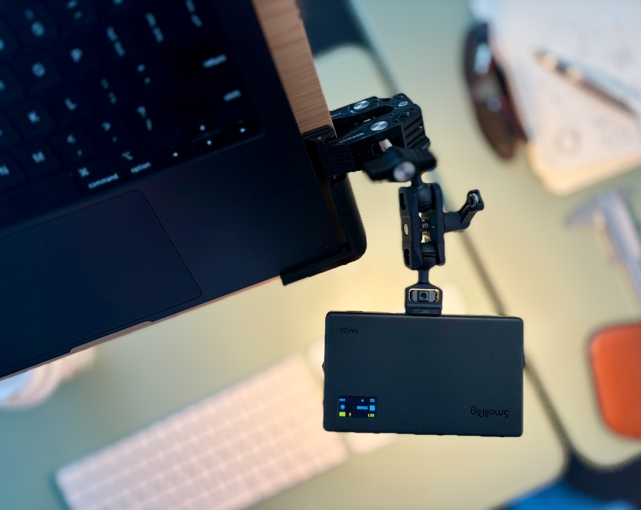 Top view of a laptop and LED panel connected by camera mounting hardware