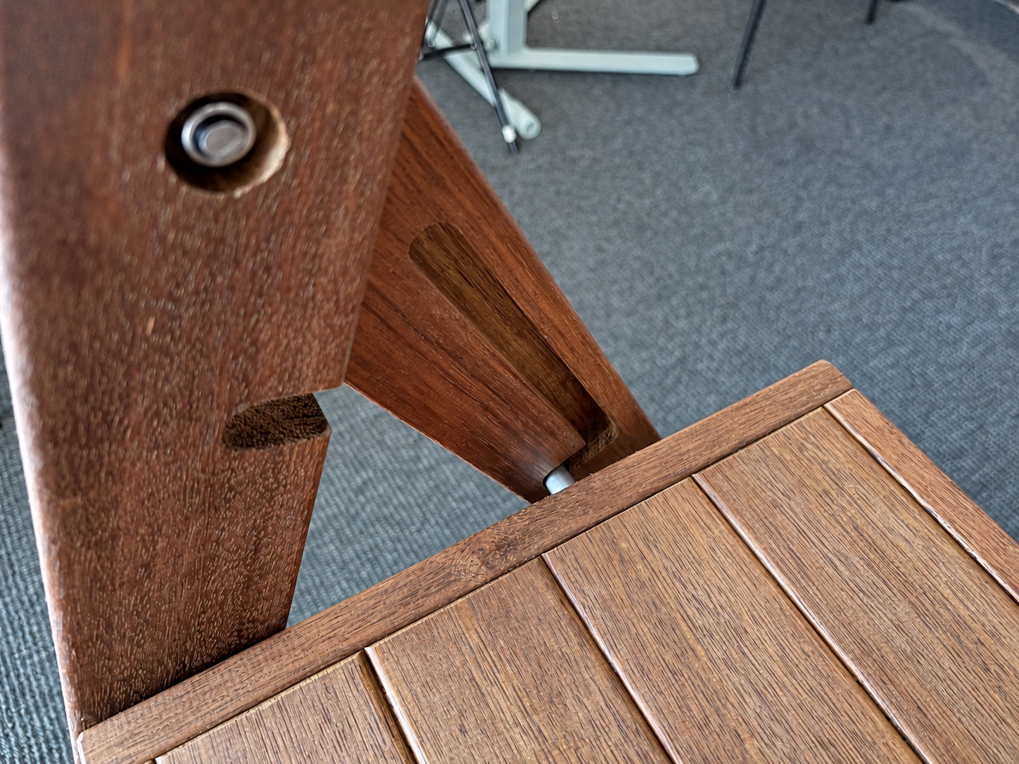 View down past the platform showing the end of the metal crossbar entering the rear-leg slot