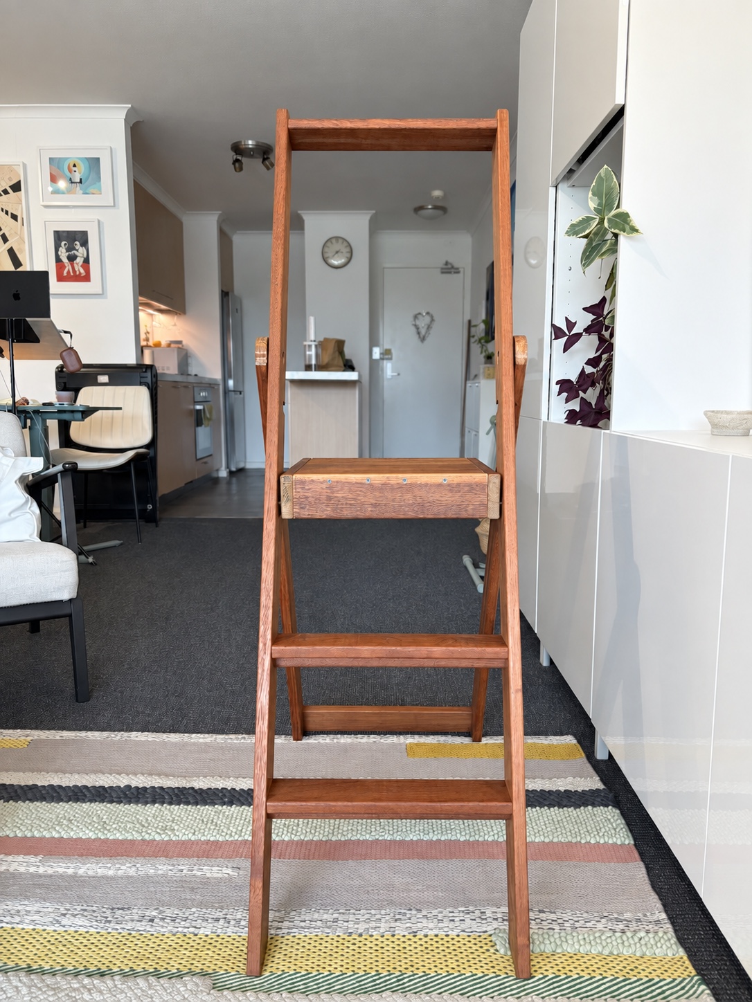 Front view of the ladder showing the lowered handrail, projecting rail ends and two lower treads